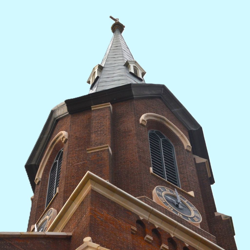 The clock, belfry, and slate spire of the bell tower at St. Paul Catholic Church, Lexington